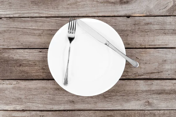 Empty plate and silverware on table — Stock Photo, Image