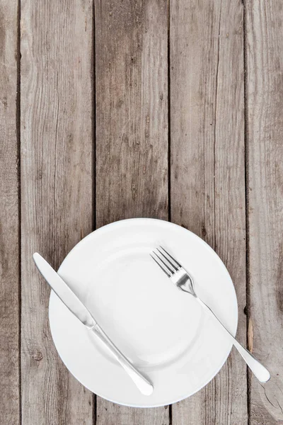 Empty plate and silverware on table — Stock Photo, Image