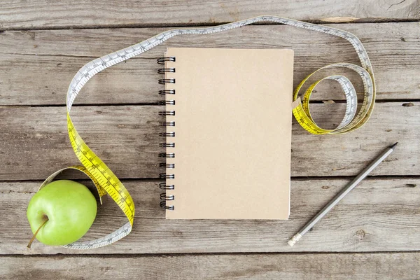 Notebook, świeżego jabłka i taśma pomiarowa — Zdjęcie stockowe