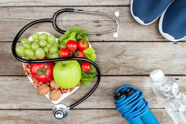 Estetoscopio, comida ecológica y equipo deportivo — Foto de Stock