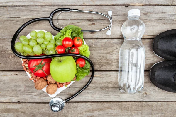 Estetoscópio, alimentos orgânicos e equipamentos esportivos — Fotografia de Stock