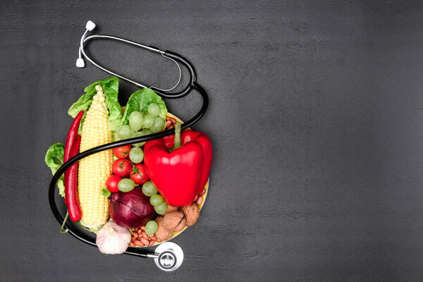 стетоскоп, органические овощи и фрукты
