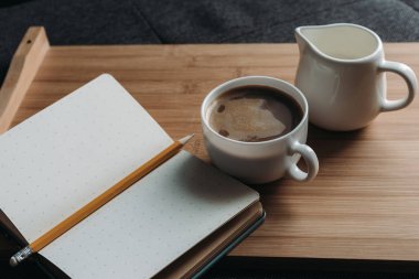 kahve, süt ve tepsi üstünde defter kabı