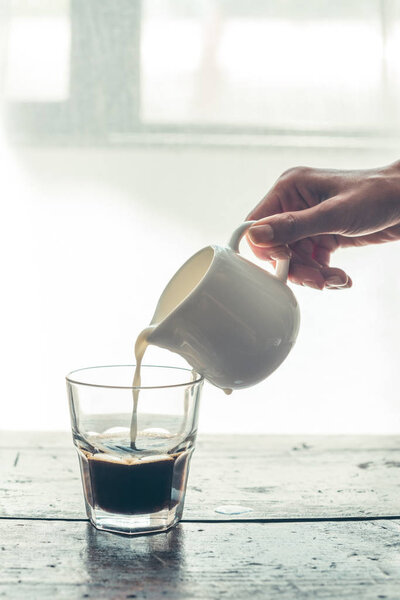 pouring milk into coffee