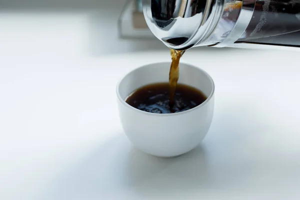 Человек, наливающий черный кофе — стоковое фото