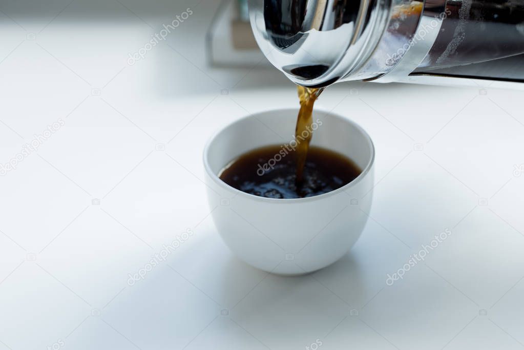 Person pouring black coffee