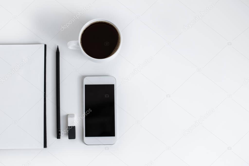 notepad and smartphone with blank screen