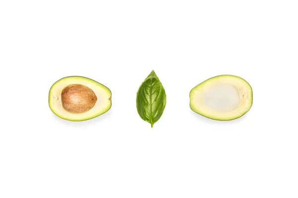 Halves of avocado and basil leaf — Stock Photo, Image