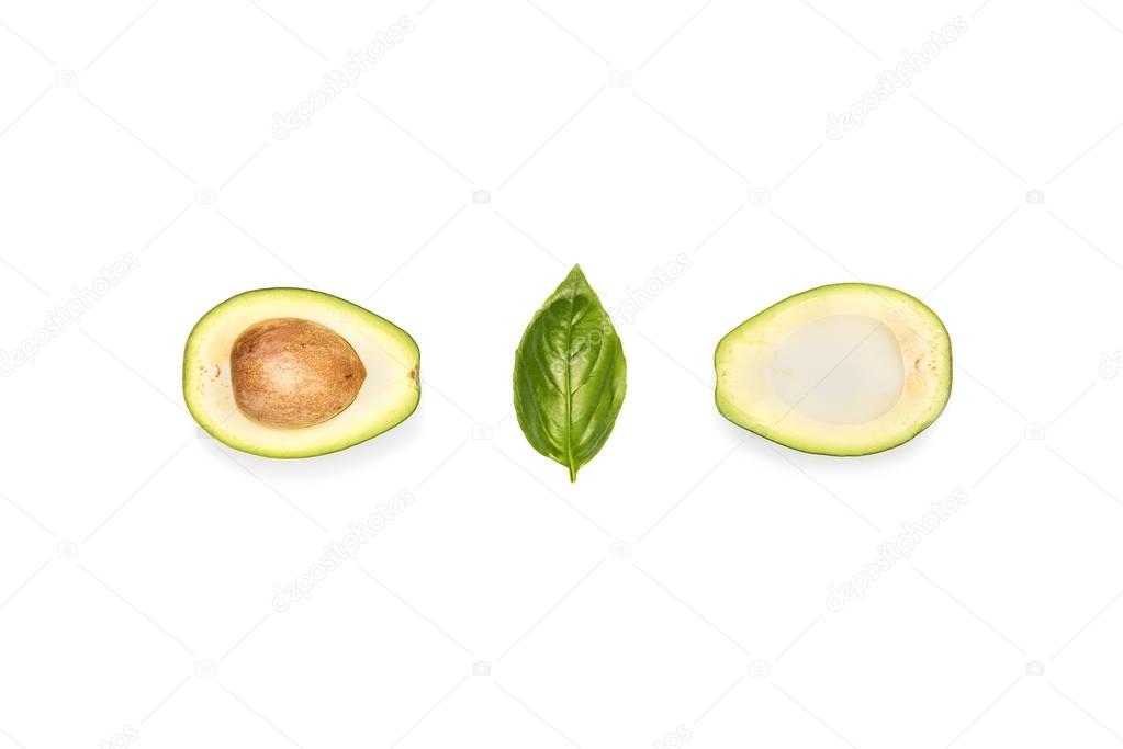 halves of avocado and basil leaf