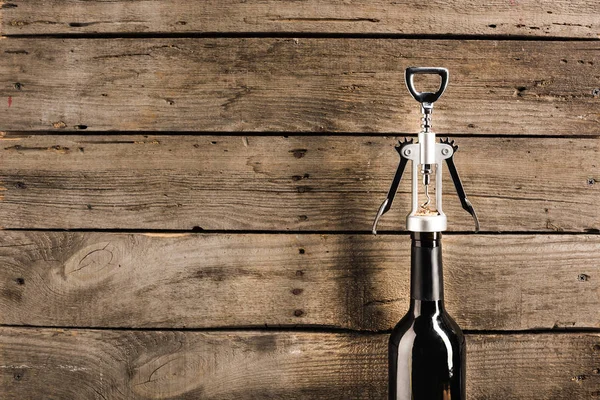 Bottle of red wine and corkscrew — Stock Photo, Image