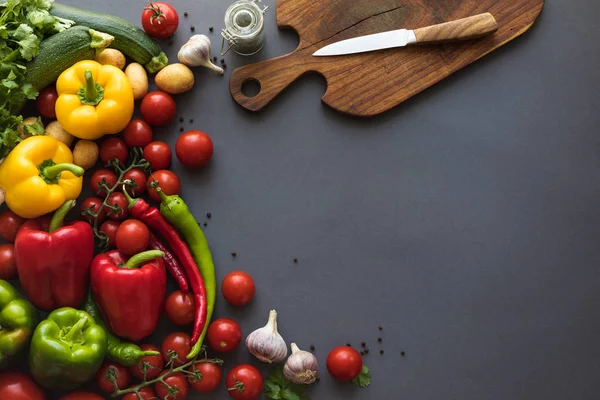 Produtos hortícolas frescos e tábua de corte — Fotografia de Stock