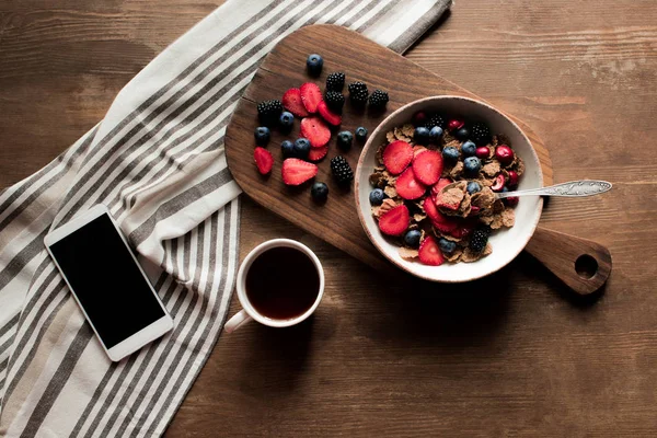 Flakes with berries and smartphone — Stock Photo, Image