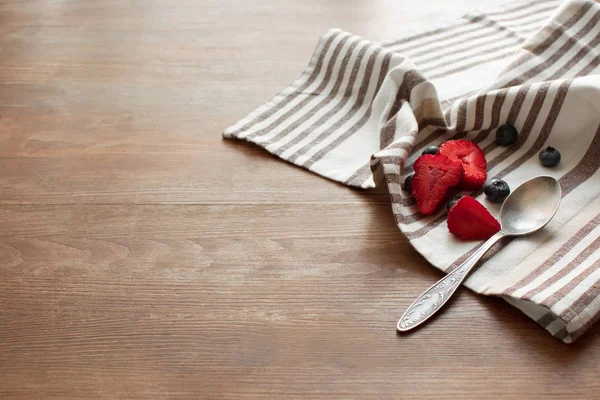 Berries and spoon on napkin — Stock Photo, Image