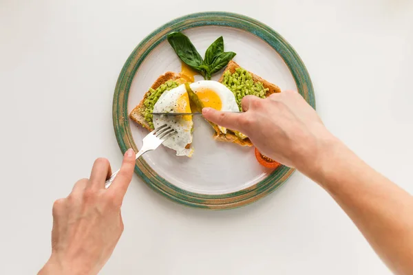 Fried egg and mashed avocado on toasts — Stock Photo, Image