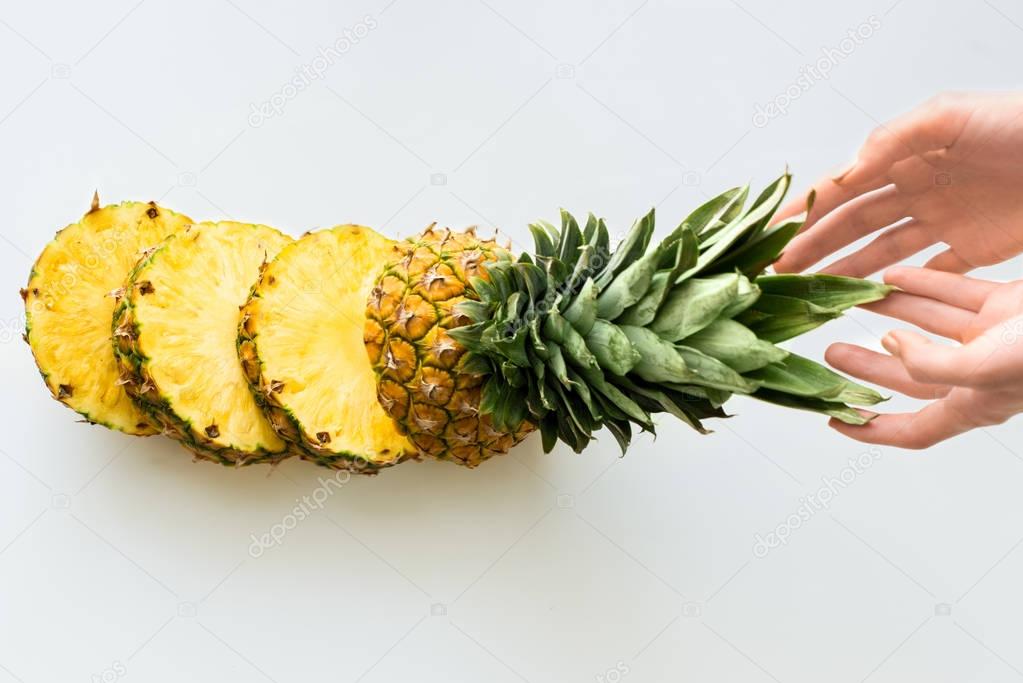hands with sliced fresh pineapple