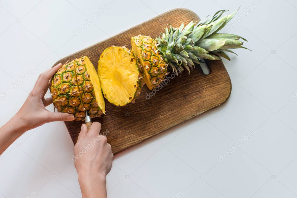 person cutting pineapple
