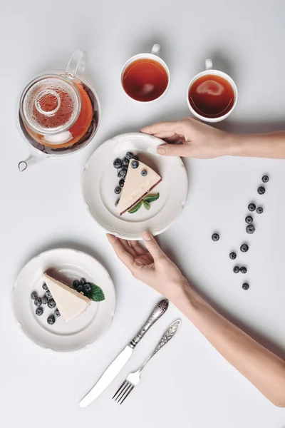 Cheesecake masada yaban mersini ile hizmet veren kadın — Stok fotoğraf