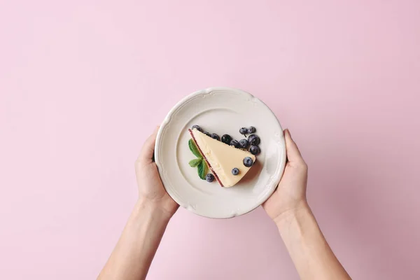 Frau hält Scheibe Käsekuchen — Stockfoto