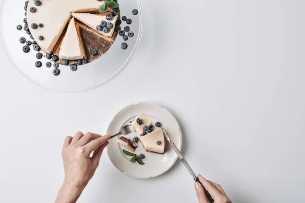 Vrouw eten cheesecake met bosbessen — Stockfoto