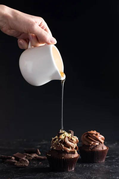 Derramando xarope em cupcake — Fotografia de Stock