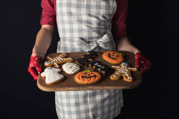 girl holding tray with halloween cookies