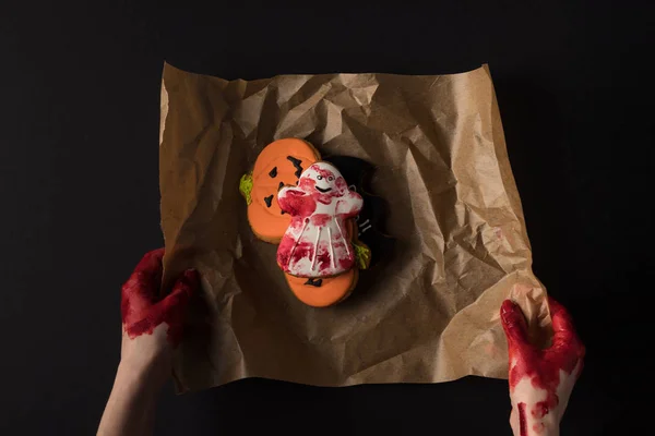 Hands wrapping halloween cookies — Stock Photo, Image