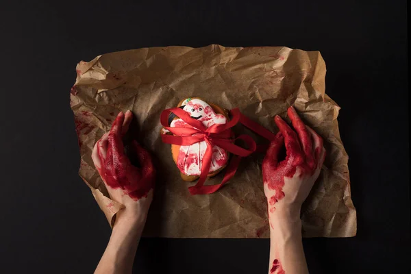 Mãos embrulhando biscoito halloween — Fotografia de Stock