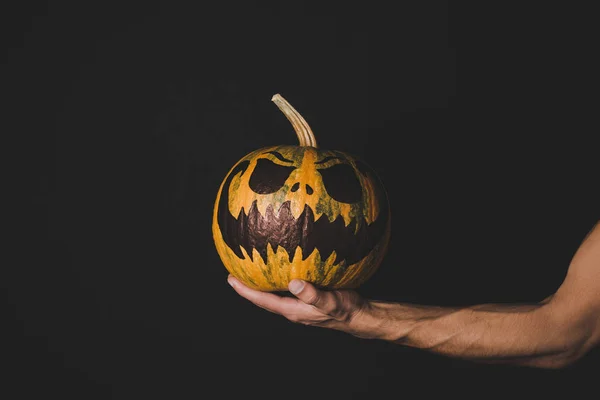 Man holding pumpkin with creepy face — Stock Photo, Image