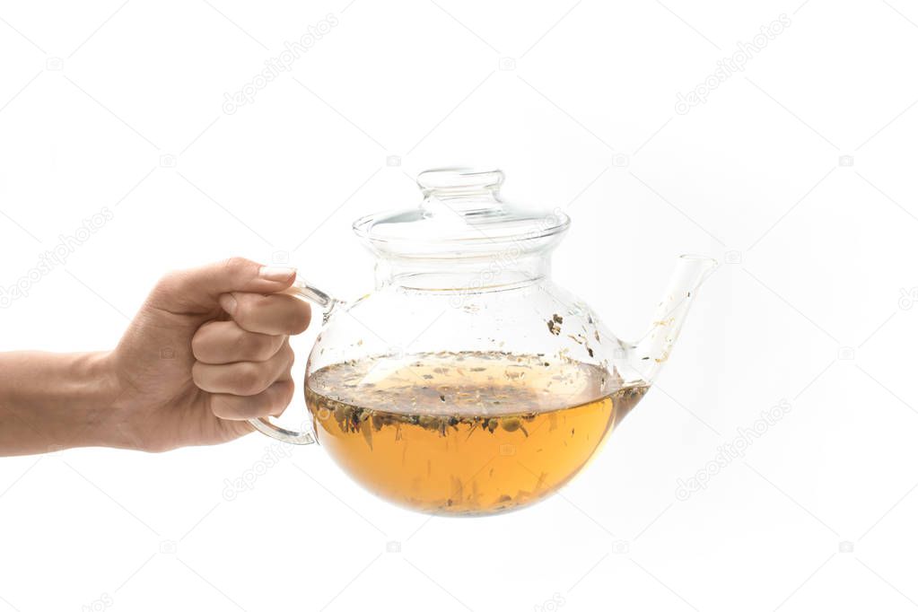 glass teapot with herbal tea in hand