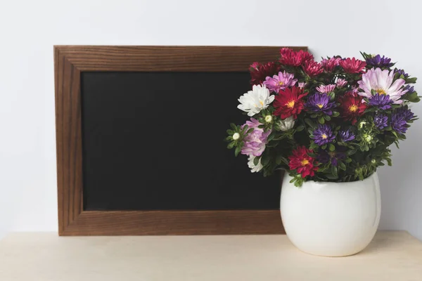 Flores em vaso e placa em branco — Fotografia de Stock