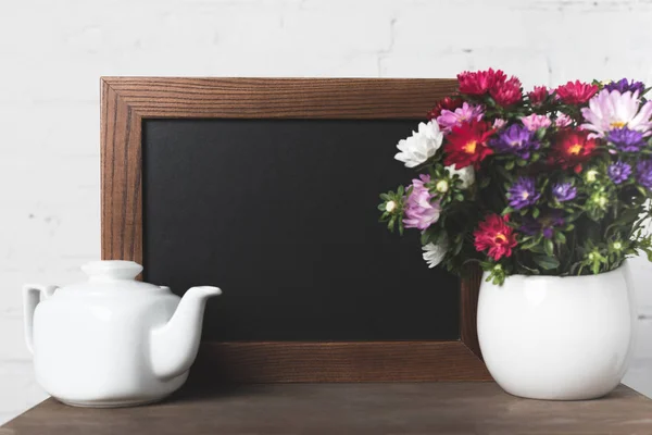 Flowers in vase and blank board — Stock Photo, Image