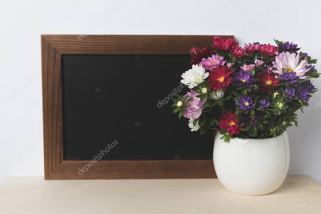 flowers in vase and blank board