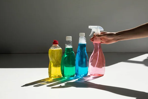 Human hand and cleaning fluids — Stock Photo, Image