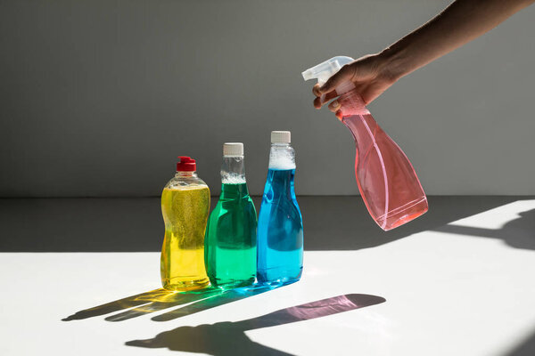 человеческая рука и чистящие жидкости
