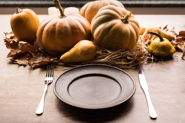 Pompoenen en bestek op tafel — Stockfoto