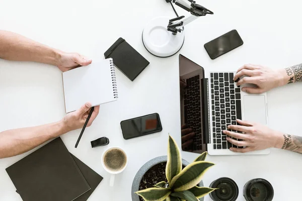 Hommes travaillant avec un ordinateur portable et un bloc-notes — Photo