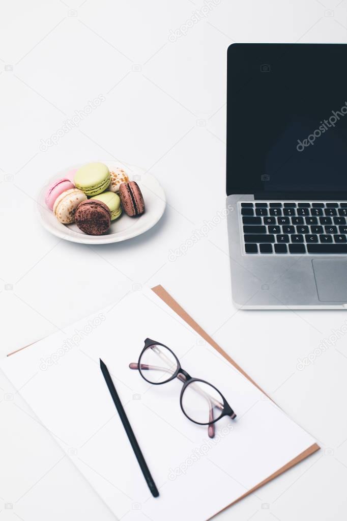 workplace with laptop and macaroons