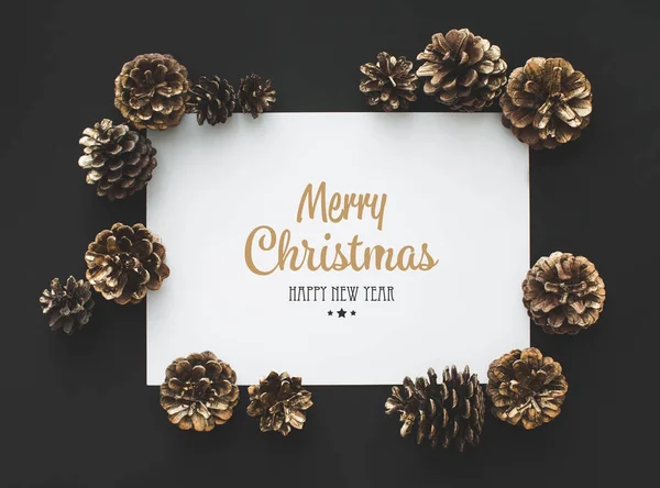 Pine cones and card with greeting — Stock Photo, Image