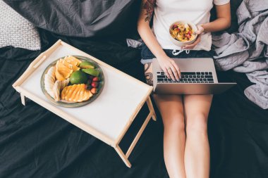 yatak üstünde laptop ile kadın