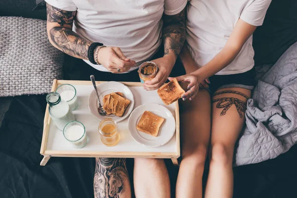 Para jedzą śniadanie razem z nimi w łóżku — Zdjęcie stockowe