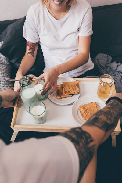 man with breakfast in bed for girlfriend