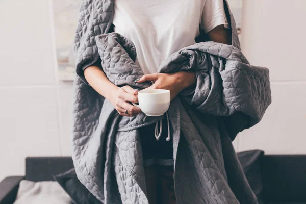 Femme dans la couverture avec une tasse de café — Photo