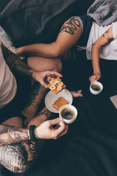 Пара с тостами и кофе в постели — стоковое фото