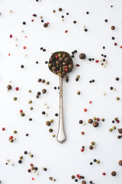 Spoon with spilled peppercorns — Stock Photo, Image