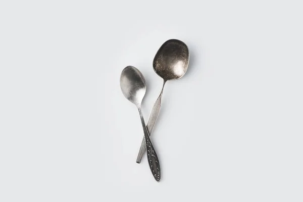 Crossed spoons on white table — Stock Photo, Image