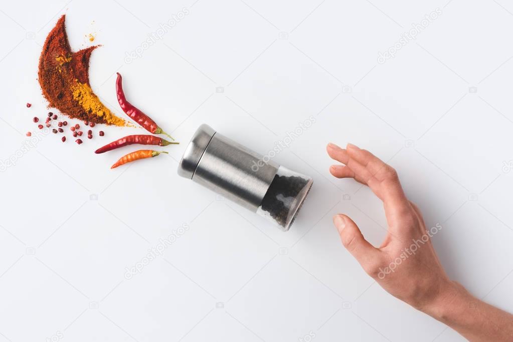 woman reaching for pepper grinder