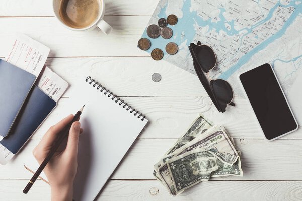 woman planning travel with notebook and pencil