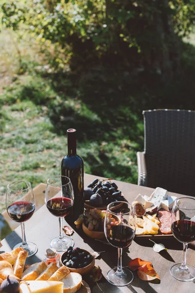 Mesa com vinho tinto e lanches — Fotografia de Stock