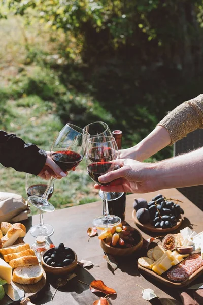 Personer klirrande glas rött vin — Stockfoto