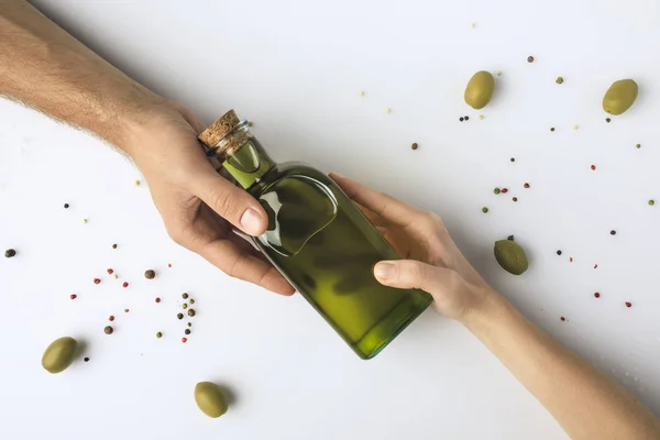 Man and woman holding bottle of oil — Stock Photo, Image